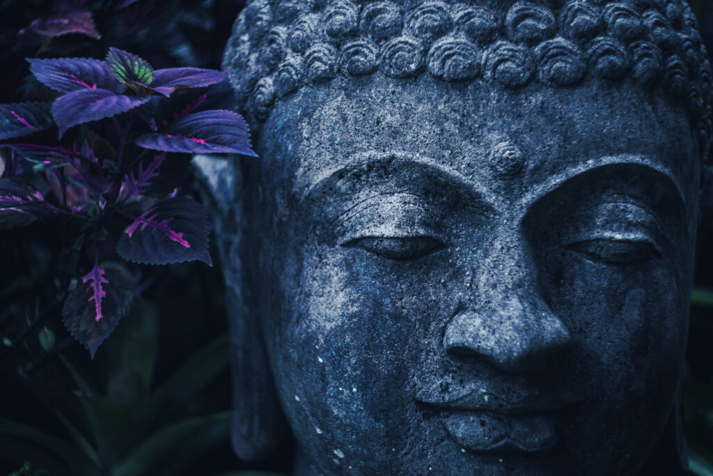 stone buddha face close up in trend blue color toning. handmade